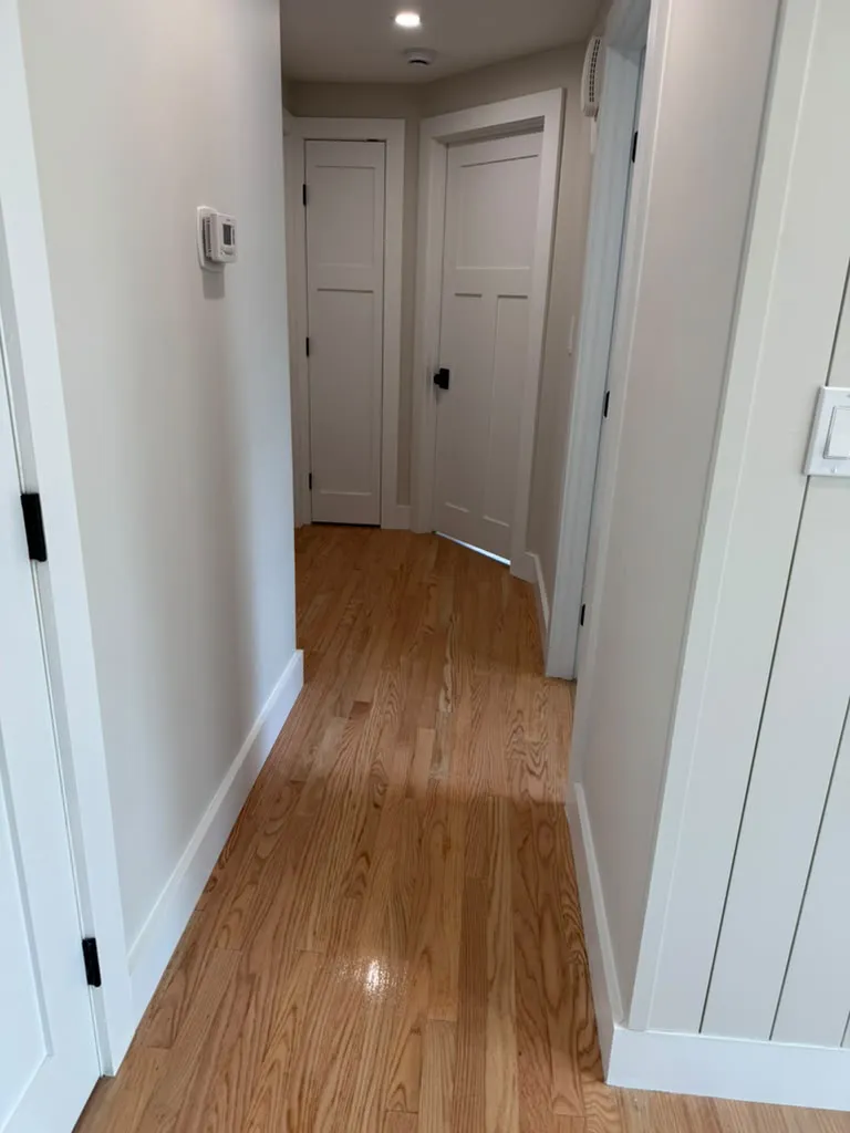 Hallway with new hardwood floor and white trim